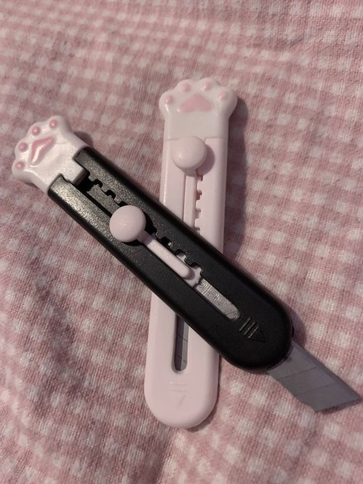 a white and black knife laying on top of a pink blanket