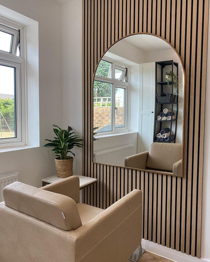 a living room filled with furniture and a large mirror on the wall next to a window