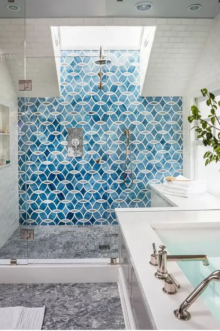 Modern bathroom with a glass-enclosed shower, featuring vibrant blue geometric tiles and a skylight. Bad Inspiration, Mediterranean Decor, Bathroom Tile Designs, Room Tiles, Bathroom Shower Tile, Trendy Bathroom, Blue Bathroom, Blue Tiles, Pacific Blue