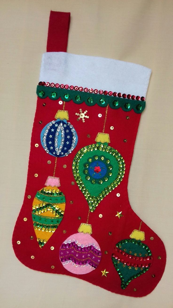 a red christmas stocking with ornaments on it