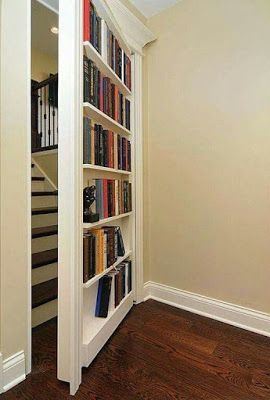 a bookshelf filled with lots of books next to a stair case in a home