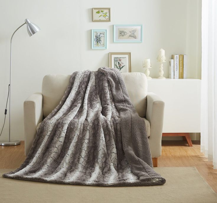 a living room with a couch and chair covered in a blanket