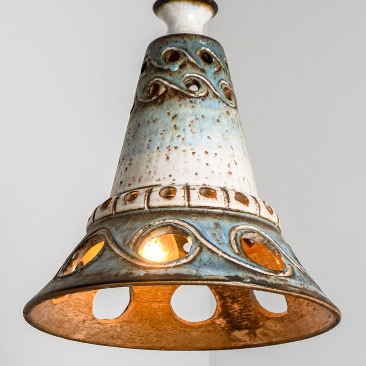 an old fashioned light hanging from a ceiling fixture with holes in the bottom and sides