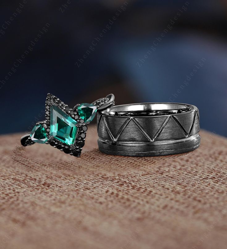 two wedding bands with an emerald colored stone