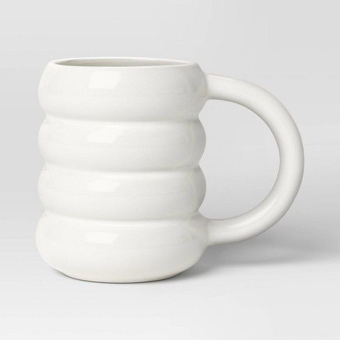 a white coffee mug sitting on top of a table