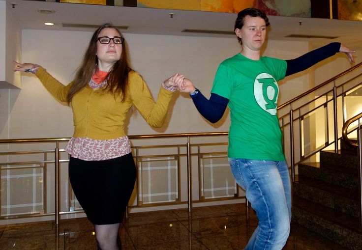 a man and woman are dancing on the stairs in front of some stairs with their arms outstretched