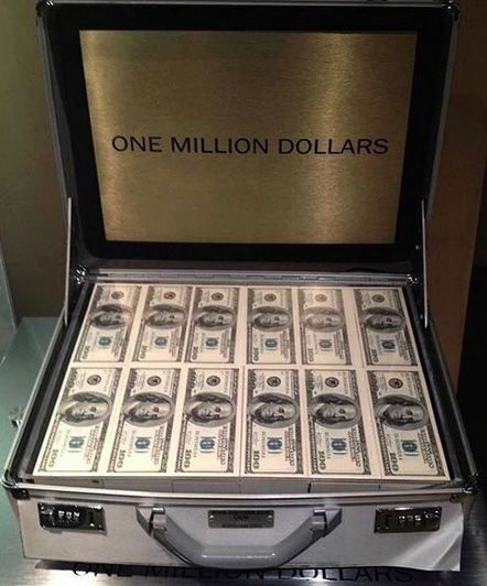 a briefcase filled with lots of money sitting on top of a table next to a wall