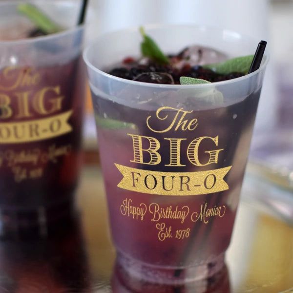 two plastic cups filled with drinks on top of a table