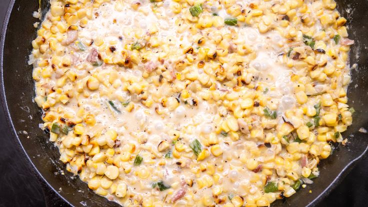 a skillet filled with corn and cheese