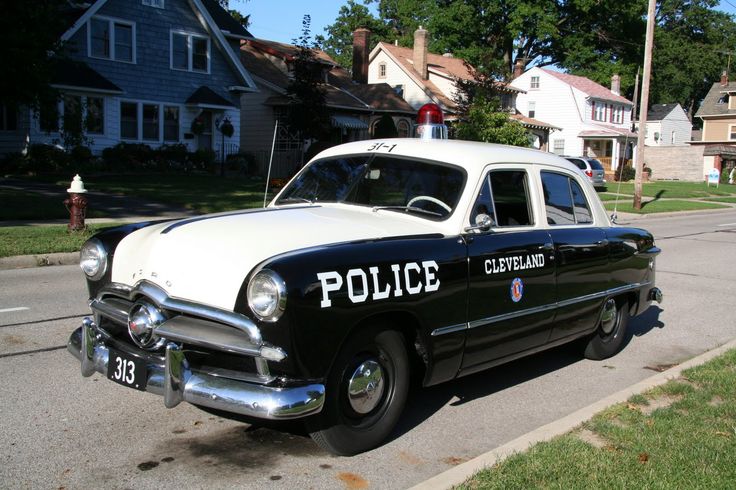 an old police car is parked on the side of the road