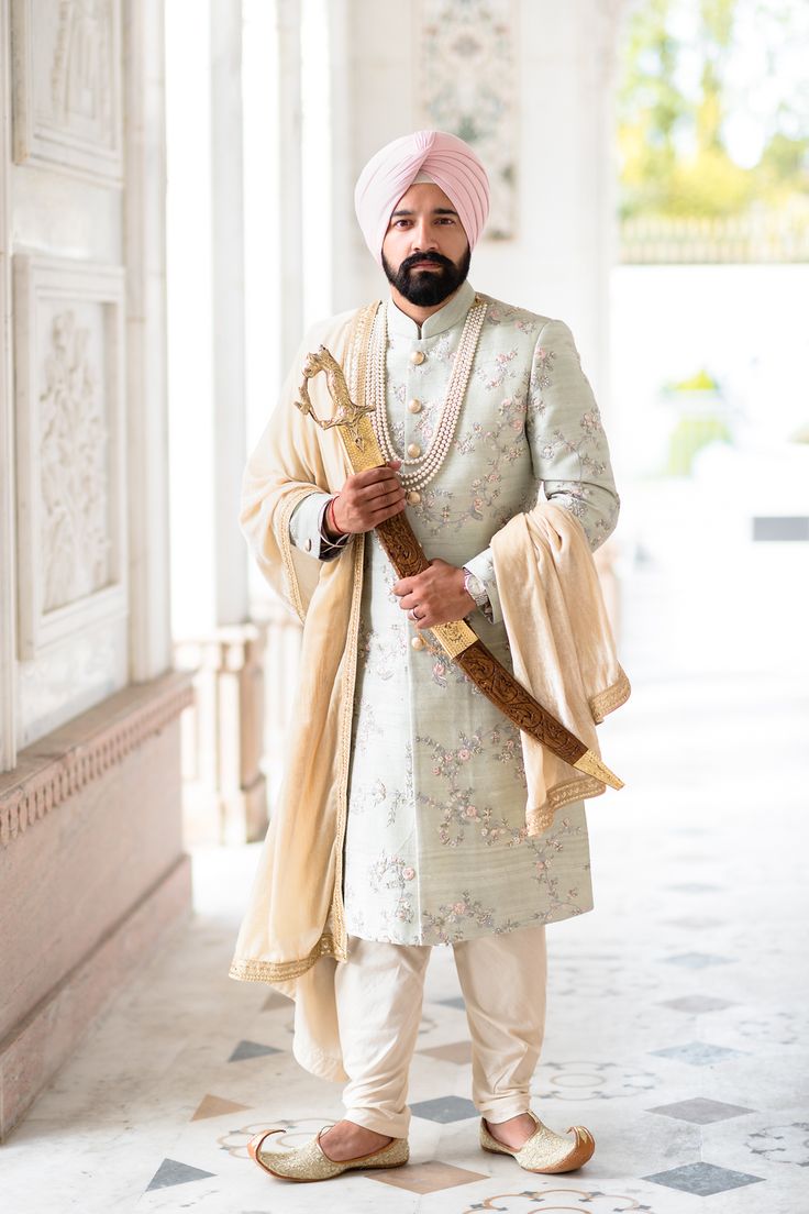 Real groom Raj wearing this eye-catching pastel mint green sherwani on his wedding day at Gravesend Gurdwara. The sherwani was from Gujralsons and his pagh was from Bespoke Turbans.  #sikhgroom #pastelsherwani #mintgreensherwani #modernsikhgroom #pinkturban #pinkpagh #sikhweddingoutfit Pista Green Sherwani Groom, Pastel Sherwani For Groom, Pastel Green Sherwani Groom, Green Indian Outfit, Indian Wedding Suits Men, Indian Groom Dress, Sherwani For Men Wedding, Wedding Dresses Men Indian, Sherwani Groom