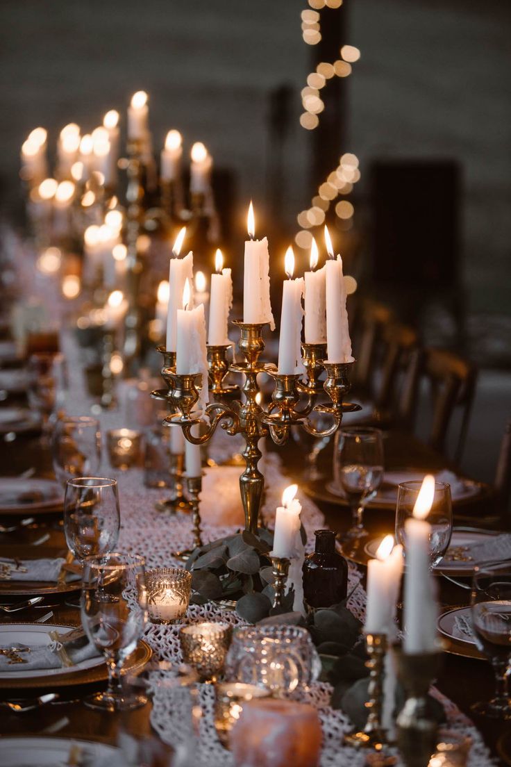 a table with candles and place settings on it