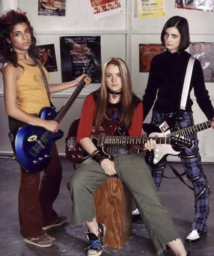 three young women with guitars posing for a photo