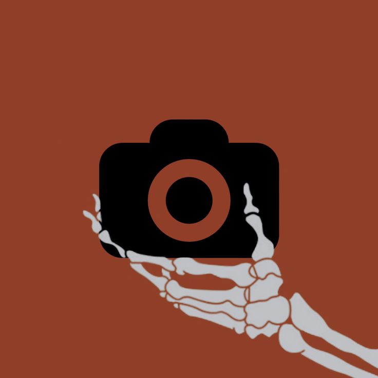 a hand holding a camera in the shape of a skeleton on a red and black background