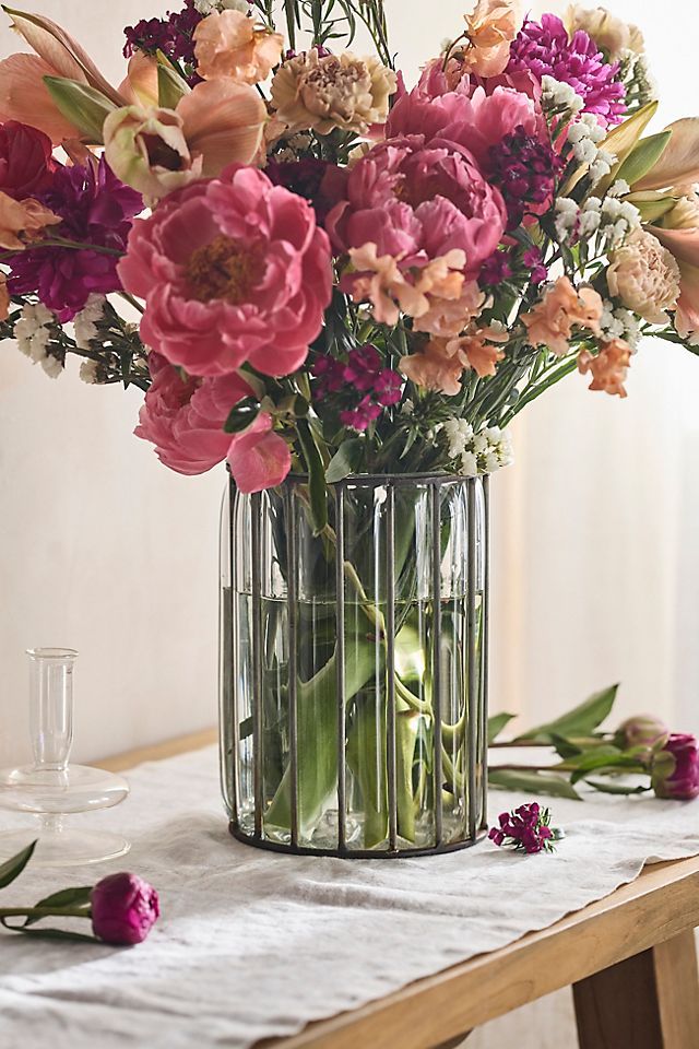 a vase filled with lots of flowers on top of a table