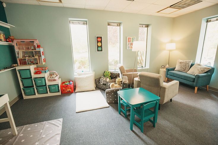 a living room filled with lots of furniture next to two windows and a rug on the floor