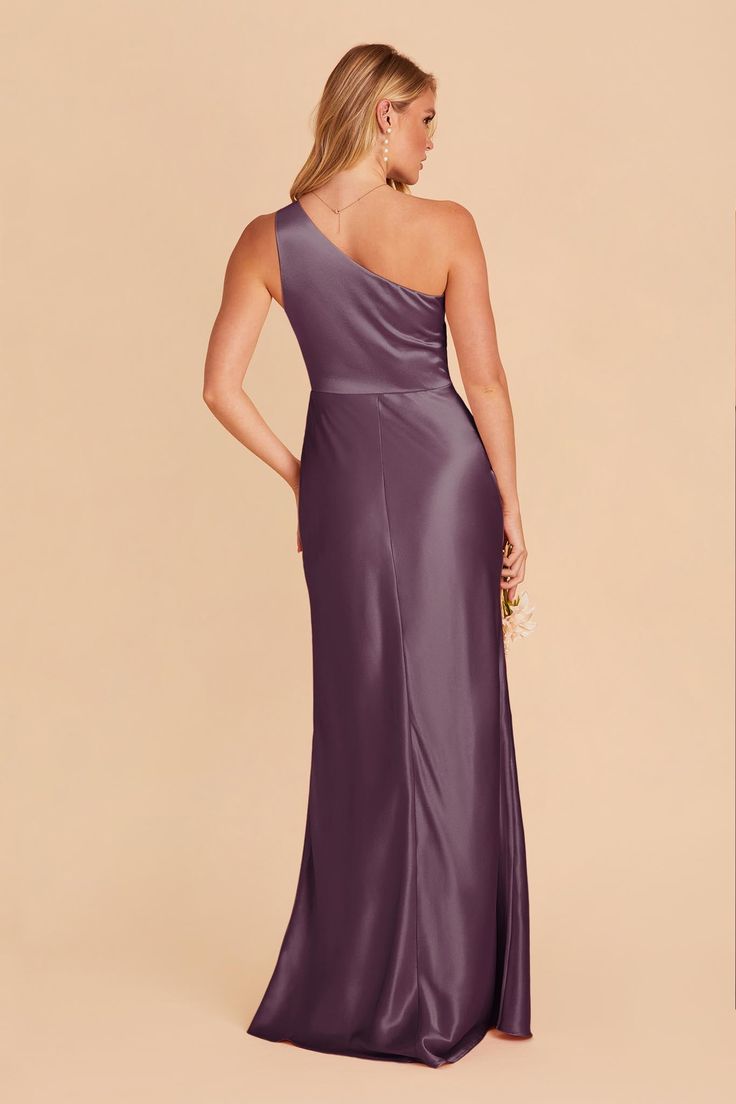 a woman in a long purple dress with one shoulder and an asymmetrical back