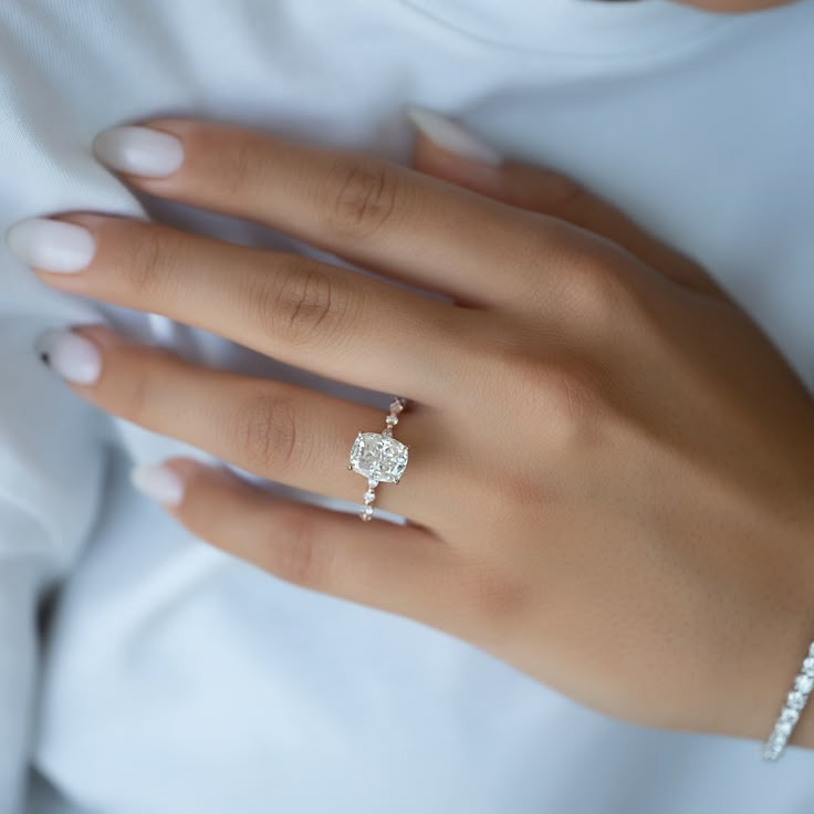 a woman's hand with a diamond ring on it