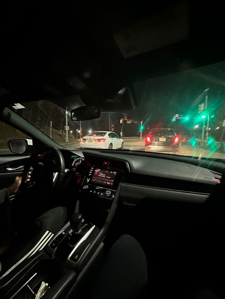 the interior of a car at night with green and red lights