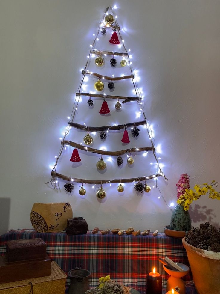 a christmas tree with lights and decorations on the wall next to a plaid couch in a living room