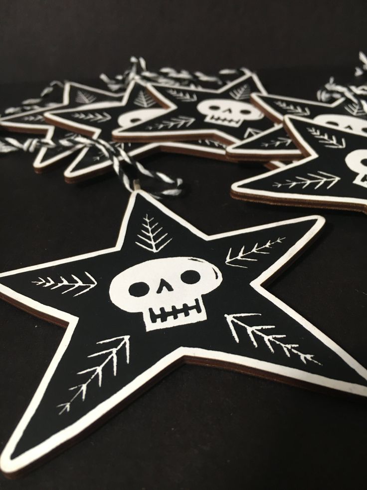 a star decorated with skulls and arrows is on the table next to other stars that have been cut out