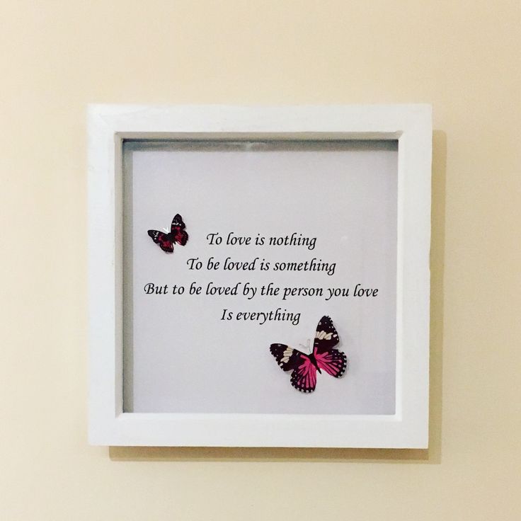 two butterflies in a white frame with a quote on the wall behind it that reads, to love is nothing