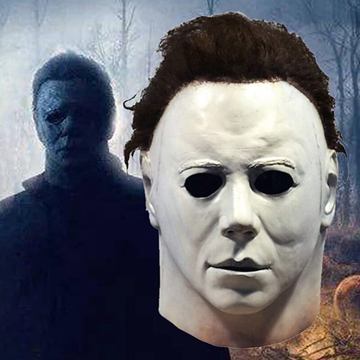 a white mask with black hair and an image of a man in the woods behind it