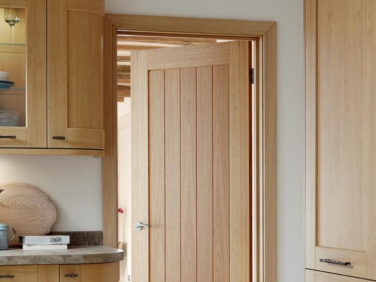 an open door in a kitchen with wooden cabinets and counter top space next to it