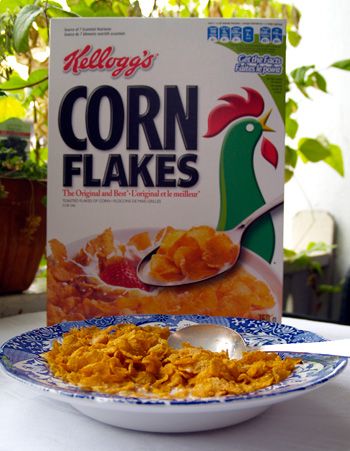 corn flakes on a blue and white plate next to a box of corn flakes