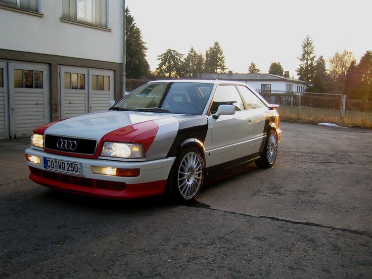 a white and red car parked in front of a building