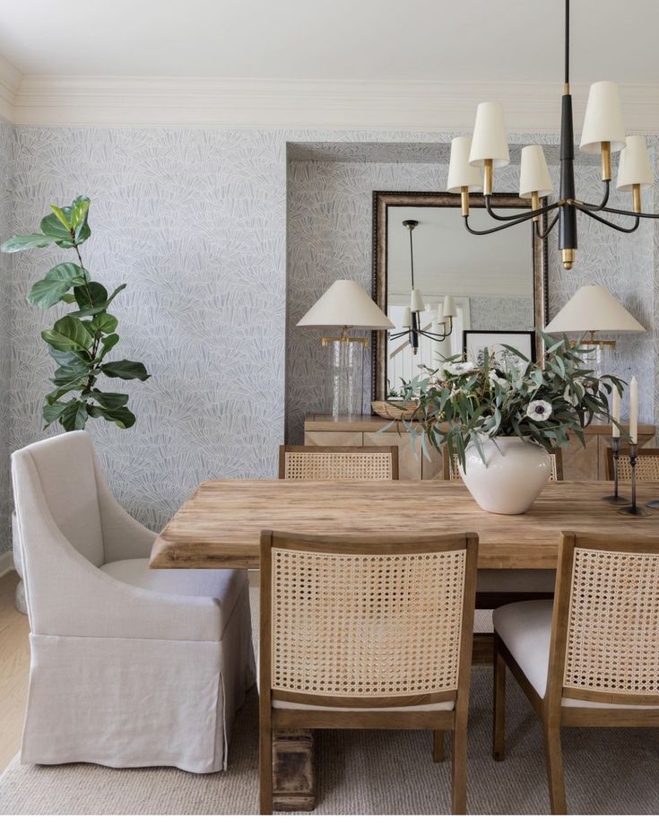 a dining room table with chairs and a mirror