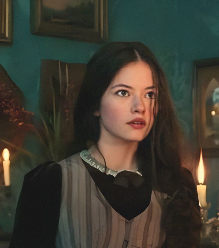 a woman with long hair standing in front of candles