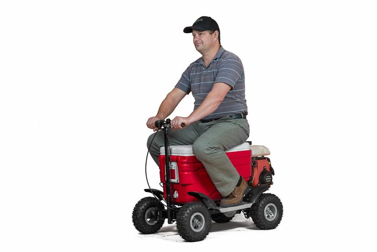 a man riding on the back of a red and white utility vehicle