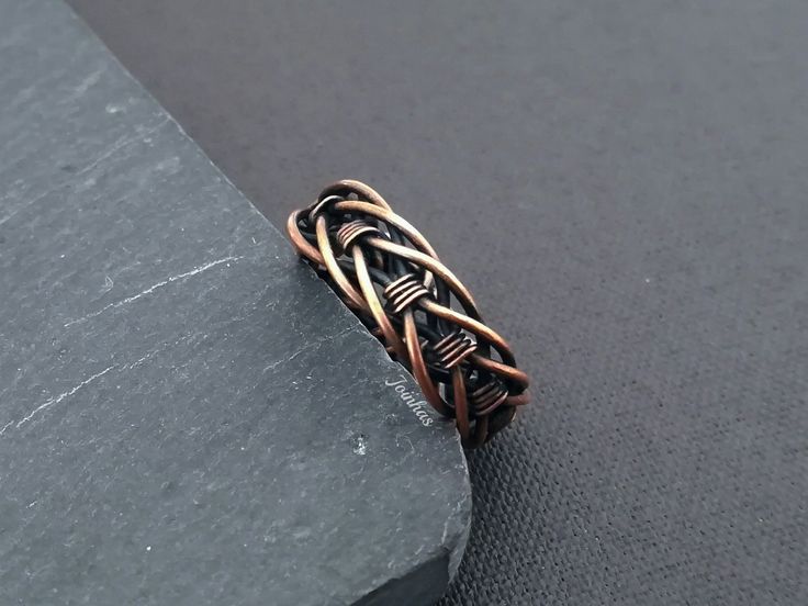 an intricate ring is sitting on top of a rock