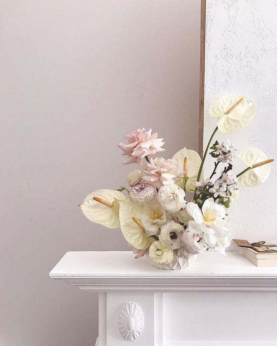 a bouquet of flowers sitting on top of a white table in front of a mirror