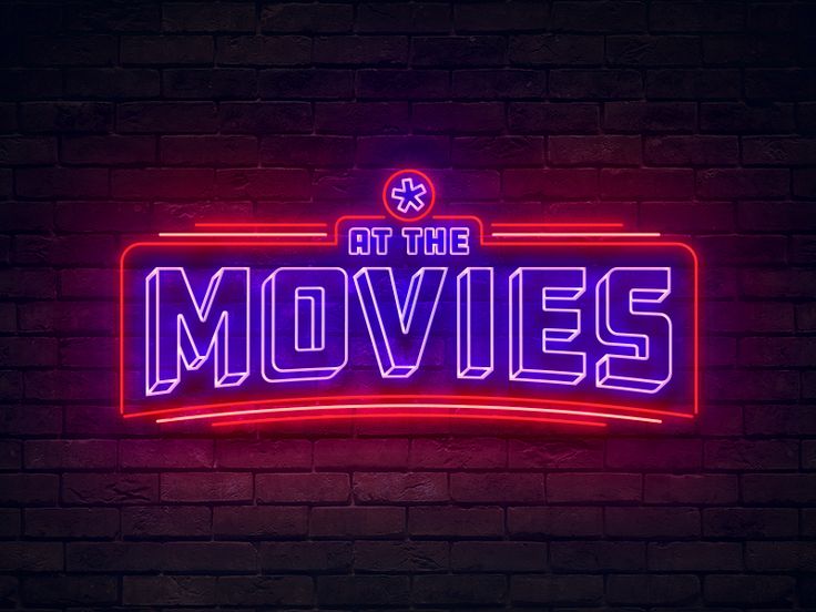 a neon sign that reads at the movies