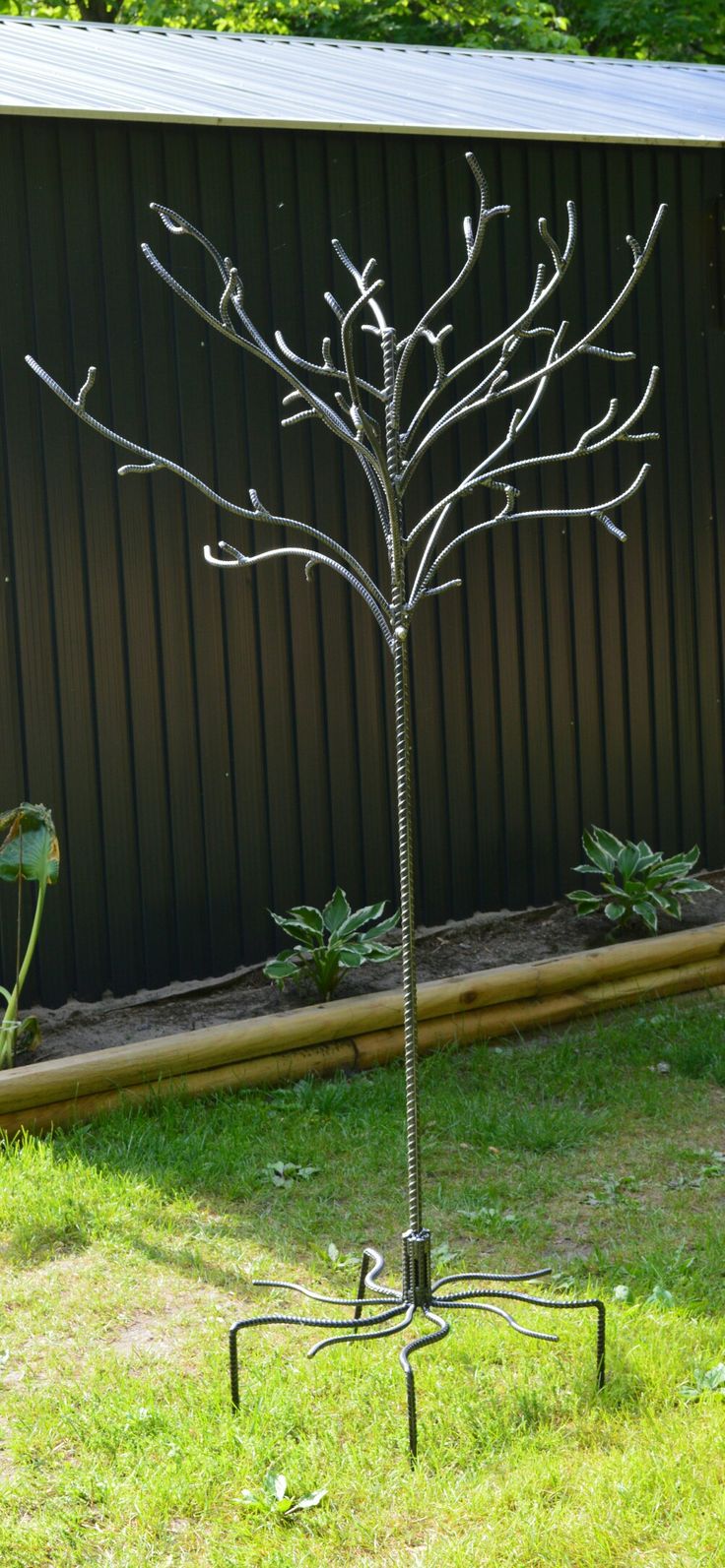 a metal tree is standing in the grass