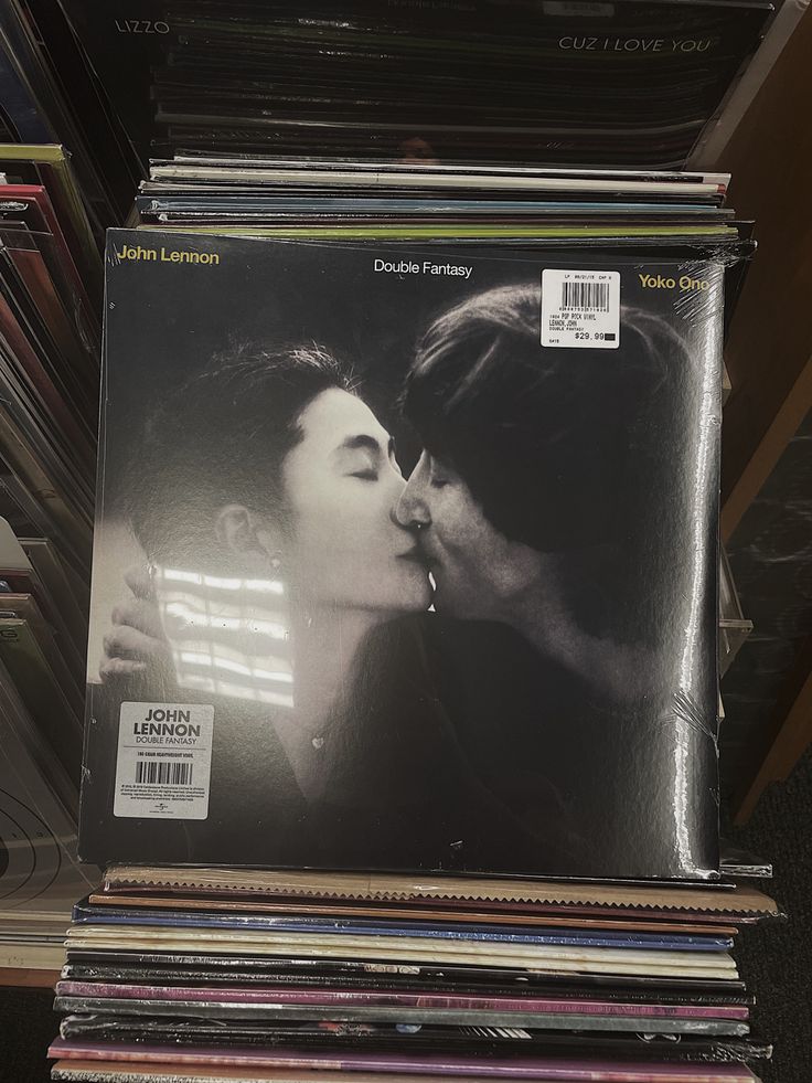 an album is stacked on top of each other in front of a stack of records