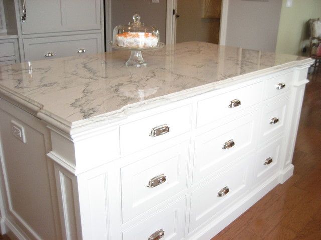 a kitchen island with marble top and drawers