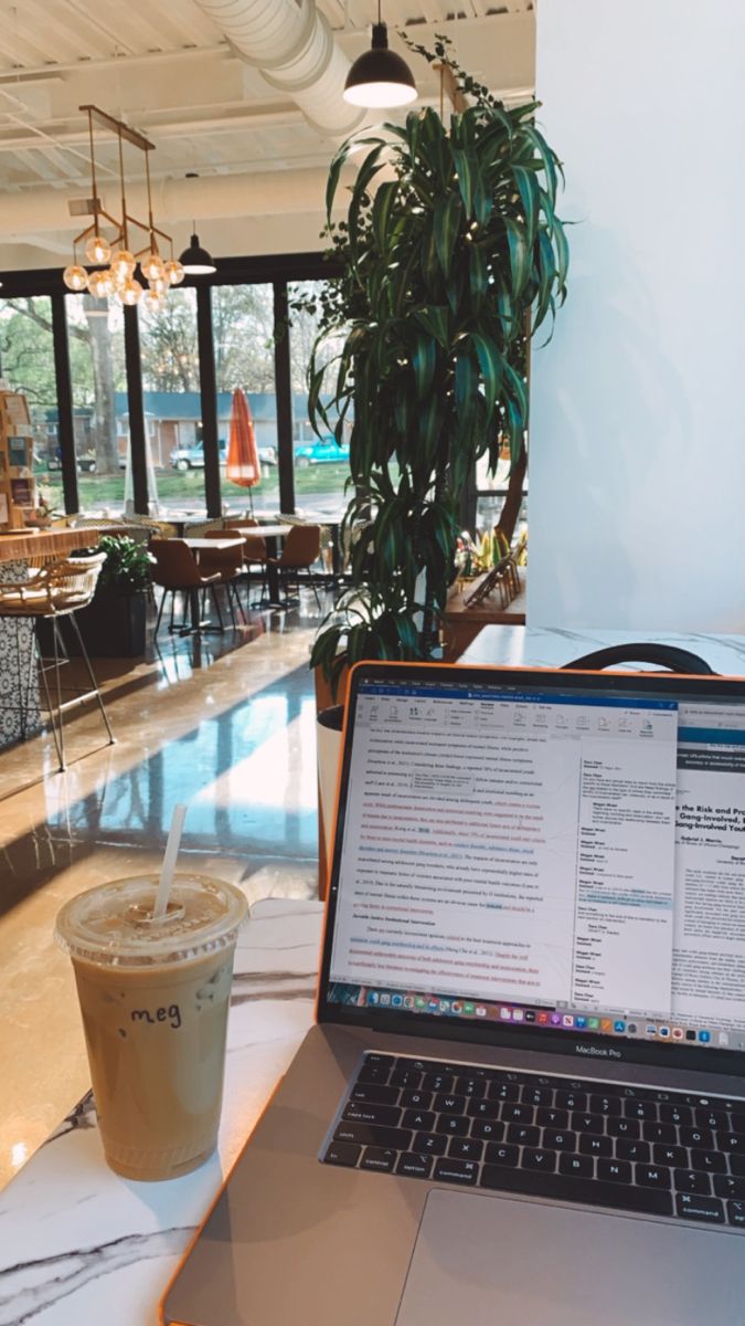 an open laptop computer sitting on top of a table next to a cup of coffee