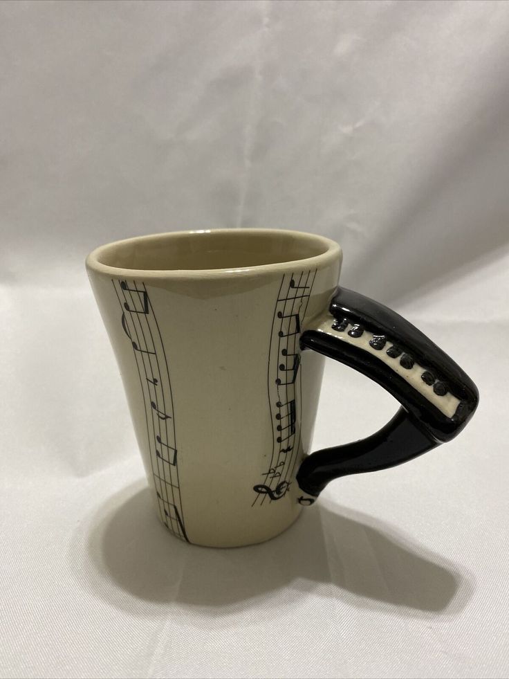 a ceramic cup with musical notes on it and a hair dryer in the shape of a mug