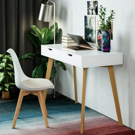 a white desk with a laptop on top of it next to a potted plant