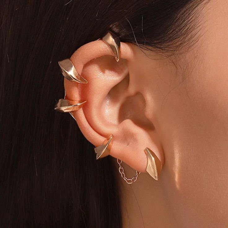 These Gothic Devil Claw Ear Cuffs, available in gleaming silver and radiant gold tones, are crafted to adorn the right ear with an air of mystical elegance. Designed to evoke the shape of pointed claws, these ear cuffs curl enticingly around the ear's contour, creating an audacious yet graceful look without the need for piercings. They are connected by a fine chain that contributes a subtle kinetic charm. Ideal for anyone looking to infuse their style with gothic sophistication, these ear cuffs Punk Mode, Ear Hangers, Punk Earrings, Ear Cuff Earings, Estilo Punk, Hip Hop Jewelry, Ear Cuffs, Fantasy Jewelry, Cuff Earrings