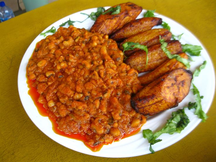 a white plate topped with beans covered in sauce