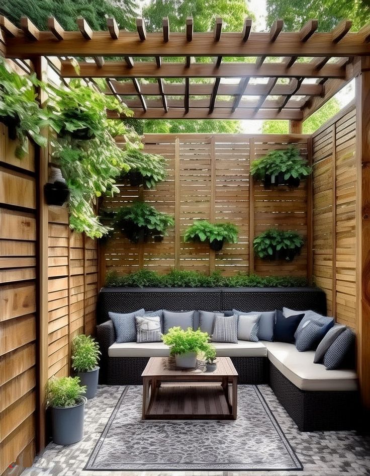 an outdoor living area with couches, tables and potted plants on the wall