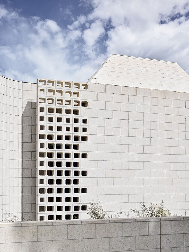 a white brick building with holes in the side and windows on it's sides