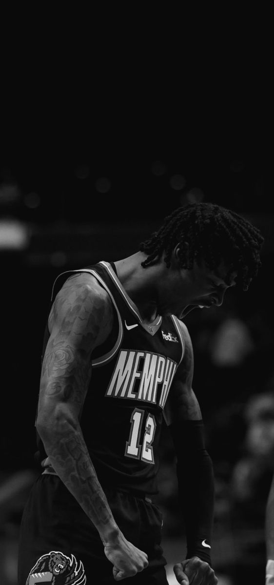 a man standing on top of a basketball court wearing a jersey and holding a ball