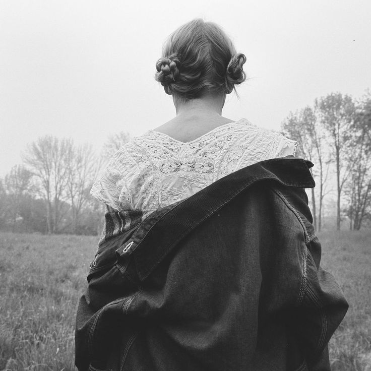 black and white photograph of a woman with her back to the camera, wearing a jacket