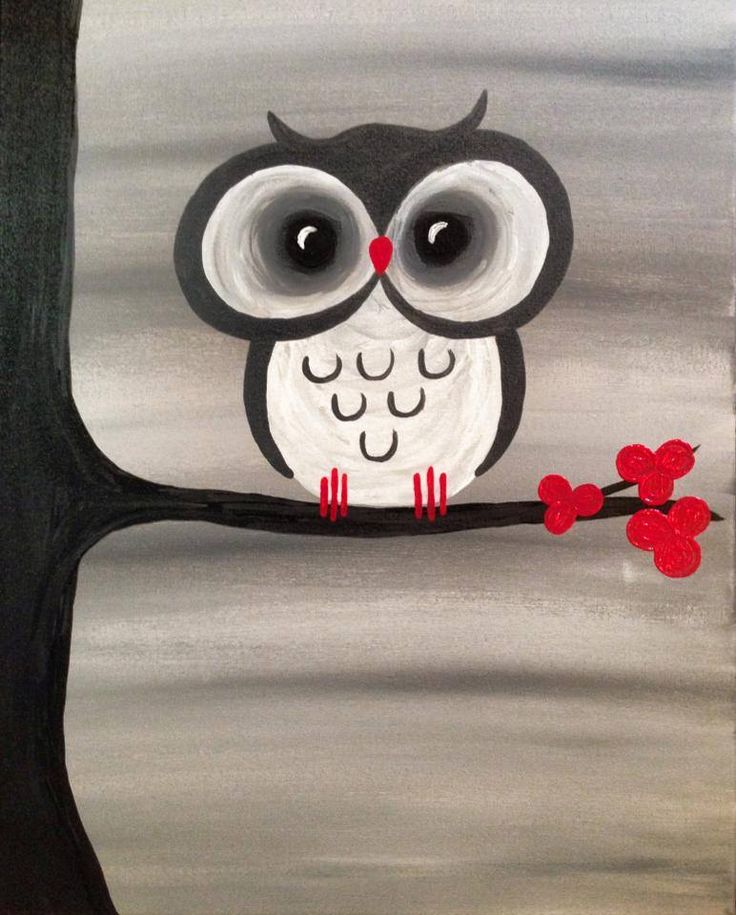 an owl sitting on a tree branch with red flowers in the foreground and gray background