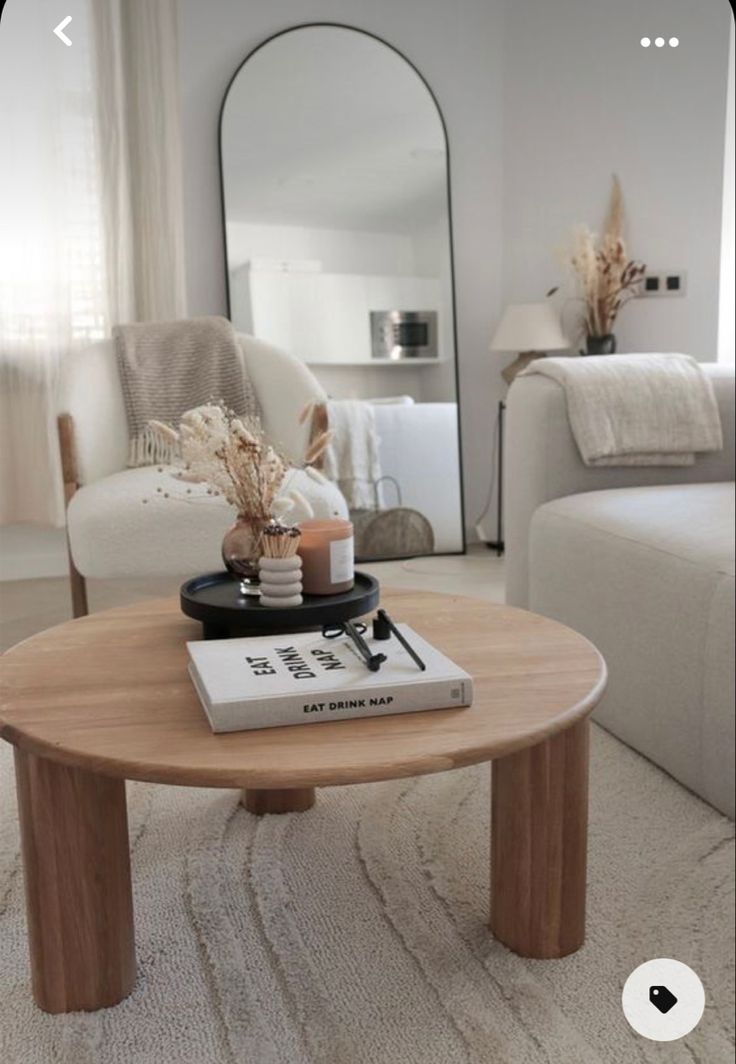 a coffee table with a book on it in the middle of a living room filled with furniture